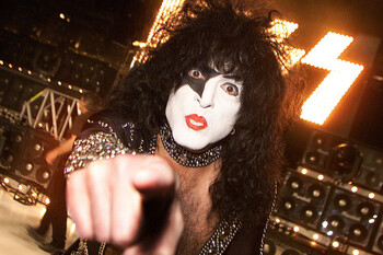 attachment paul stanley in front of kiss sign pointing at the camera